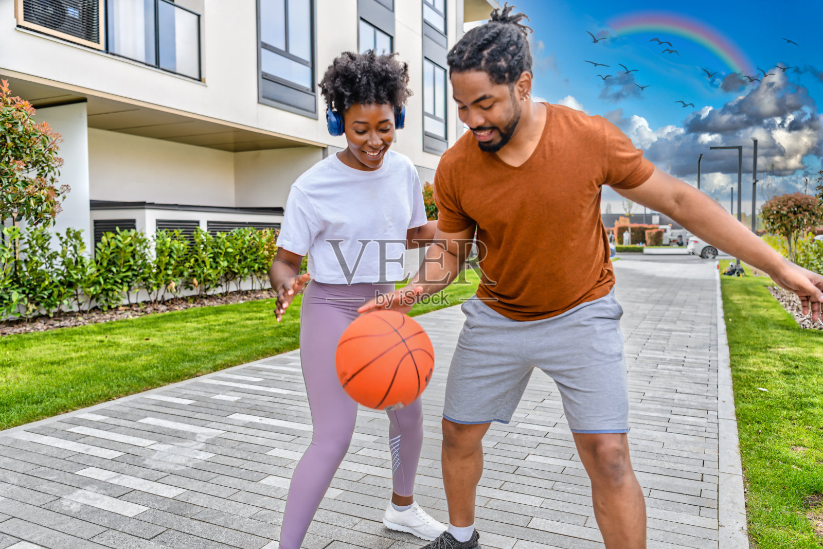 一个快乐的非裔美国人家庭正在街上玩篮球。照片摄影图片