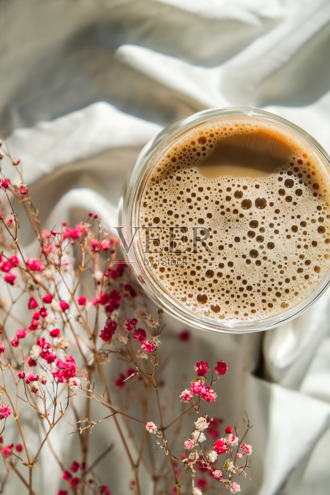 一杯拿铁卡布奇诺。早晨的咖啡美学氛围。早餐。粉色满天星花照片摄影图片
