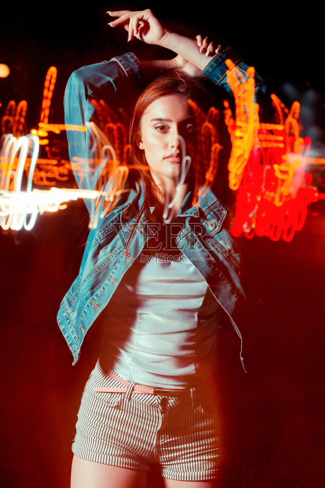 漂亮的年轻女子在混合灯光技术在夜晚的大街照片摄影图片