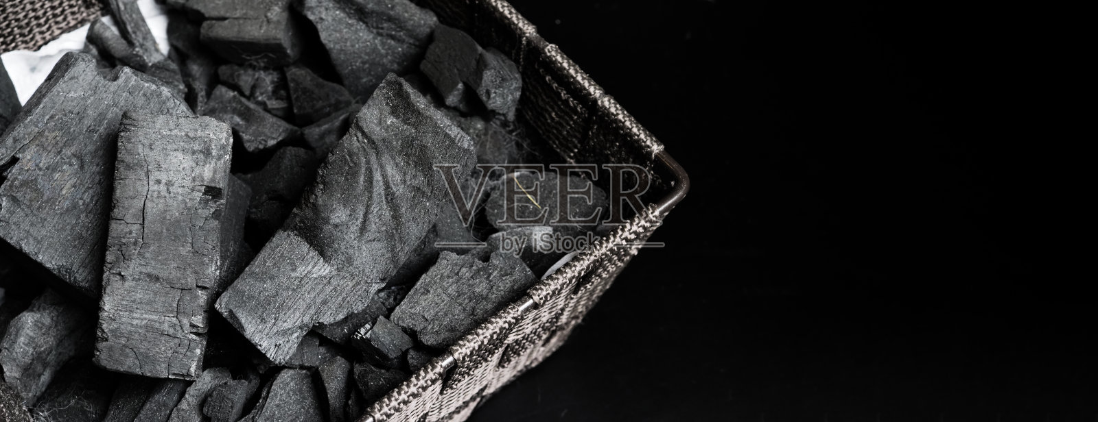 黑色纹理地板上的黑色木炭。木炭强烈加热木材而产生的黑炭残留物。用于烹饪或其他行业。天然木炭。传统的硬木木炭。照片摄影图片