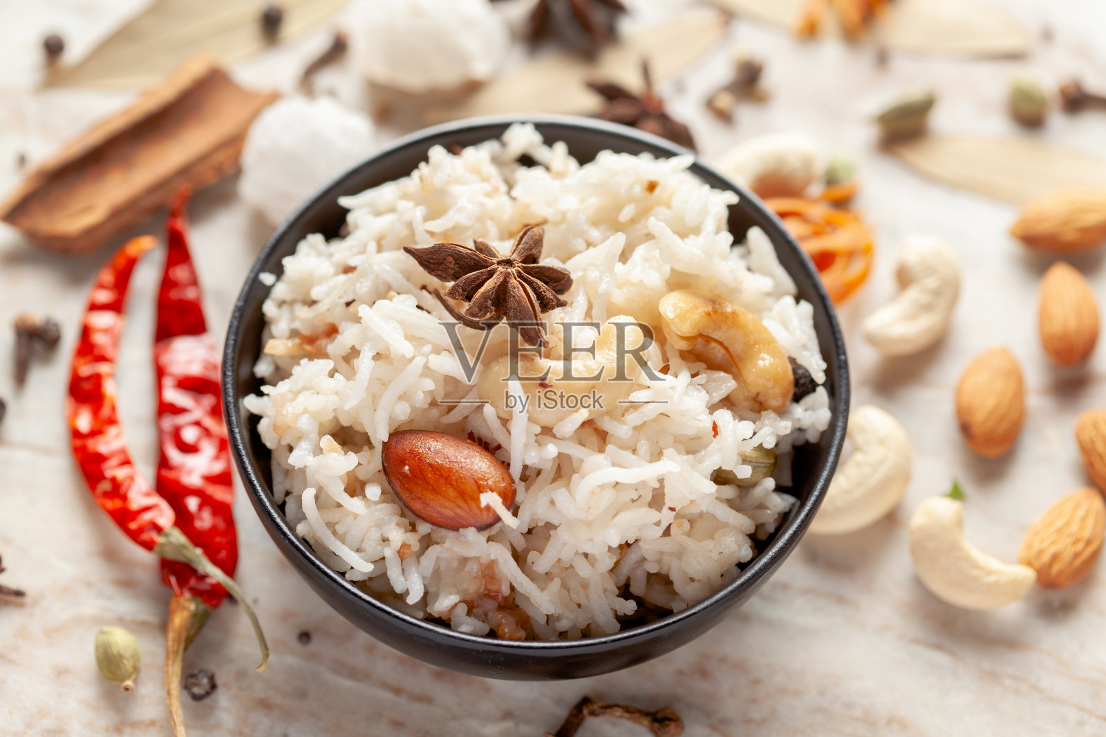 特写印度香米或Kasmiri pulao (pulav)或干果pulao配以干果和香料在一个黑色的碗里照片摄影图片
