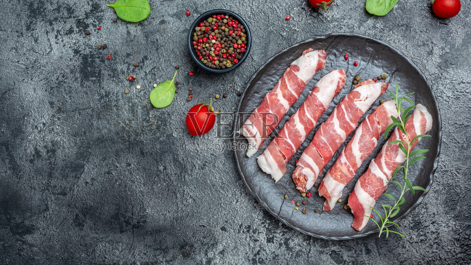 用香草和香料在培根中烹饪肉卷。生酮饮食，俯视图。文本的地方照片摄影图片