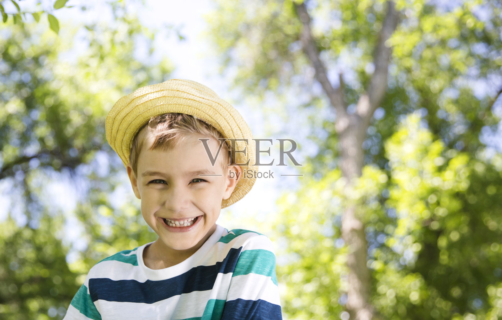 戴着草帽的小男孩在夏日的大自然中微笑。暑假照片摄影图片
