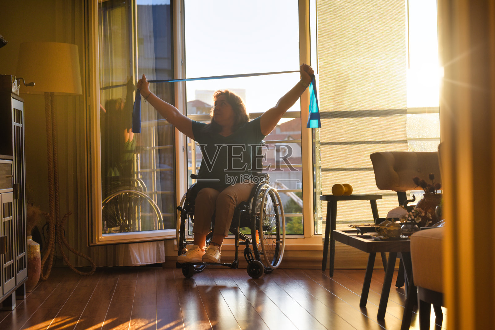 坐在轮椅上的妇女与阻力带一起锻炼照片摄影图片