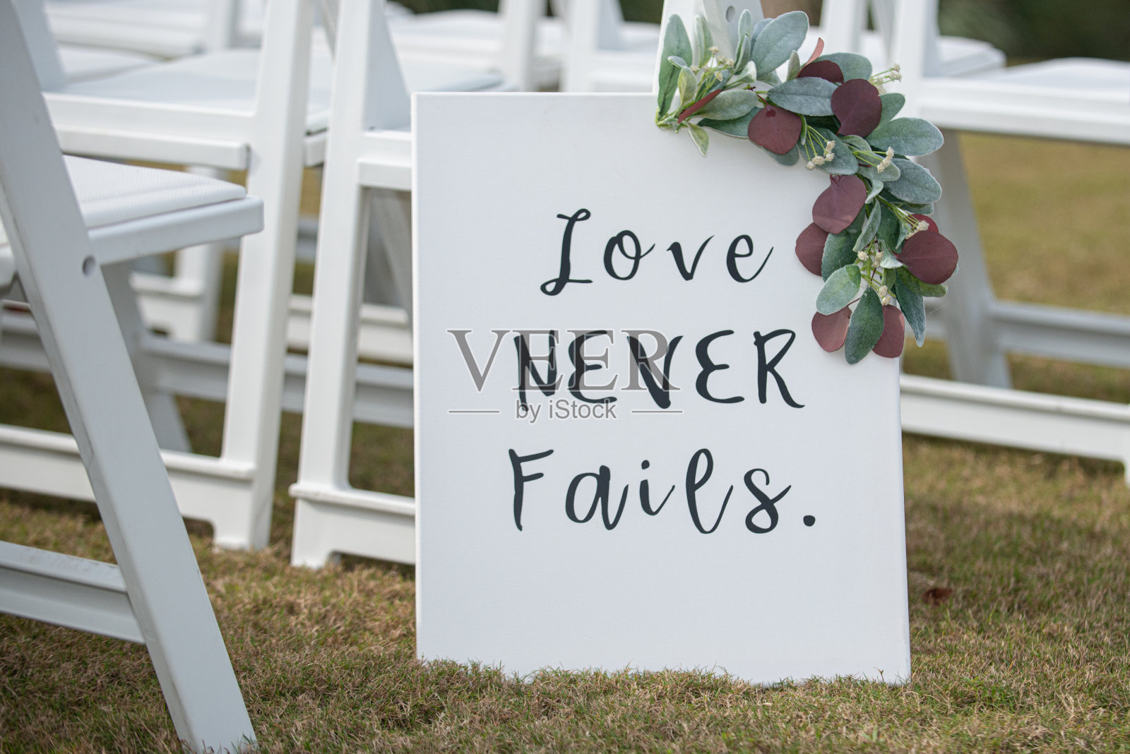 “爱从不失败”白色标志在婚礼岛装饰照片摄影图片