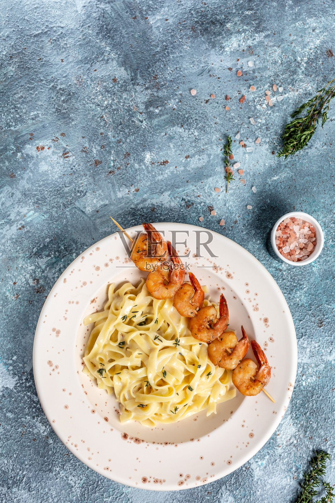 鲜虾和奶油酱意大利面，青柠和香草，浅蓝色餐桌。意大利菜。长条幅格式，俯视图照片摄影图片