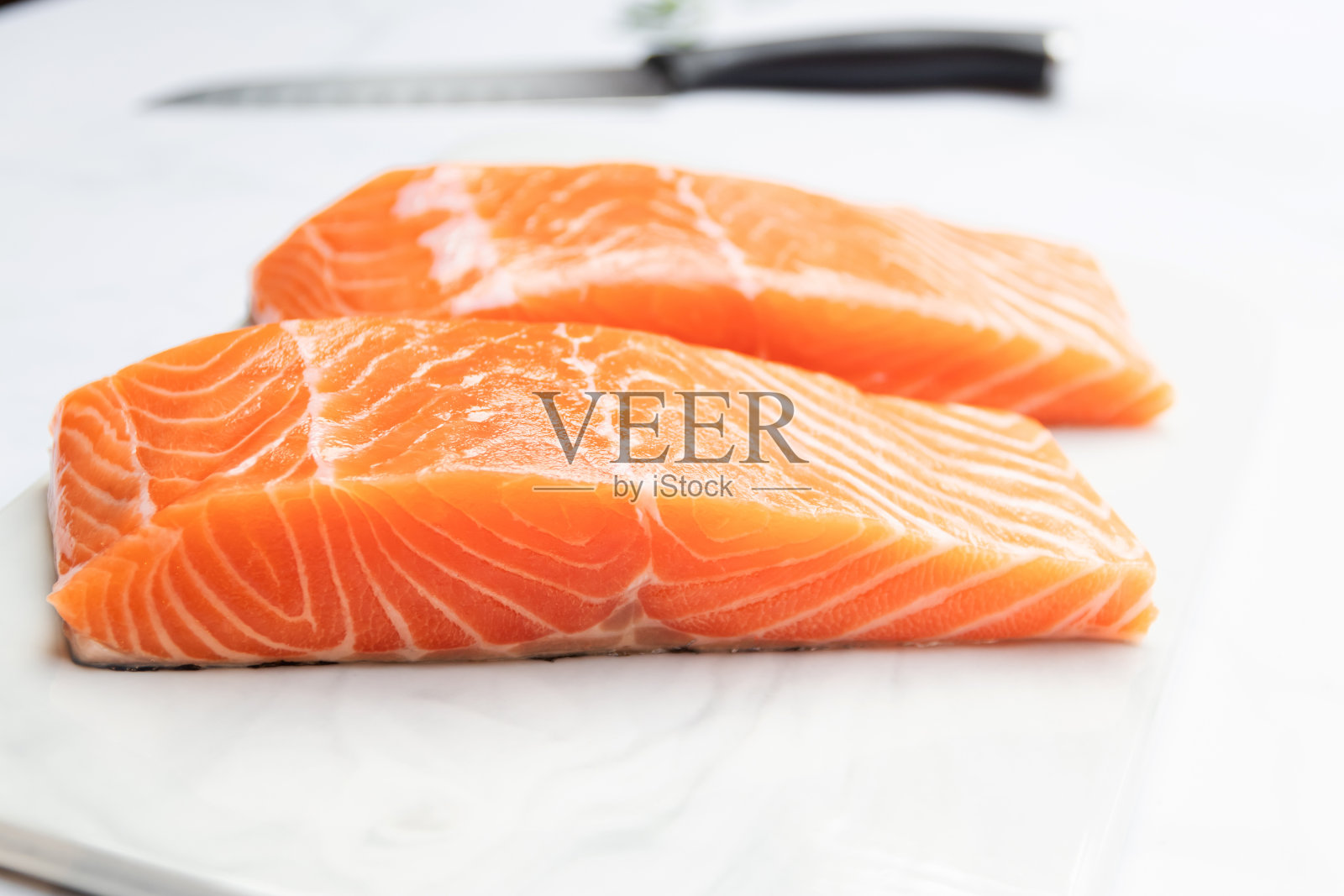 大理石盘子上的新鲜三文鱼片配美味的三文鱼排。照片摄影图片