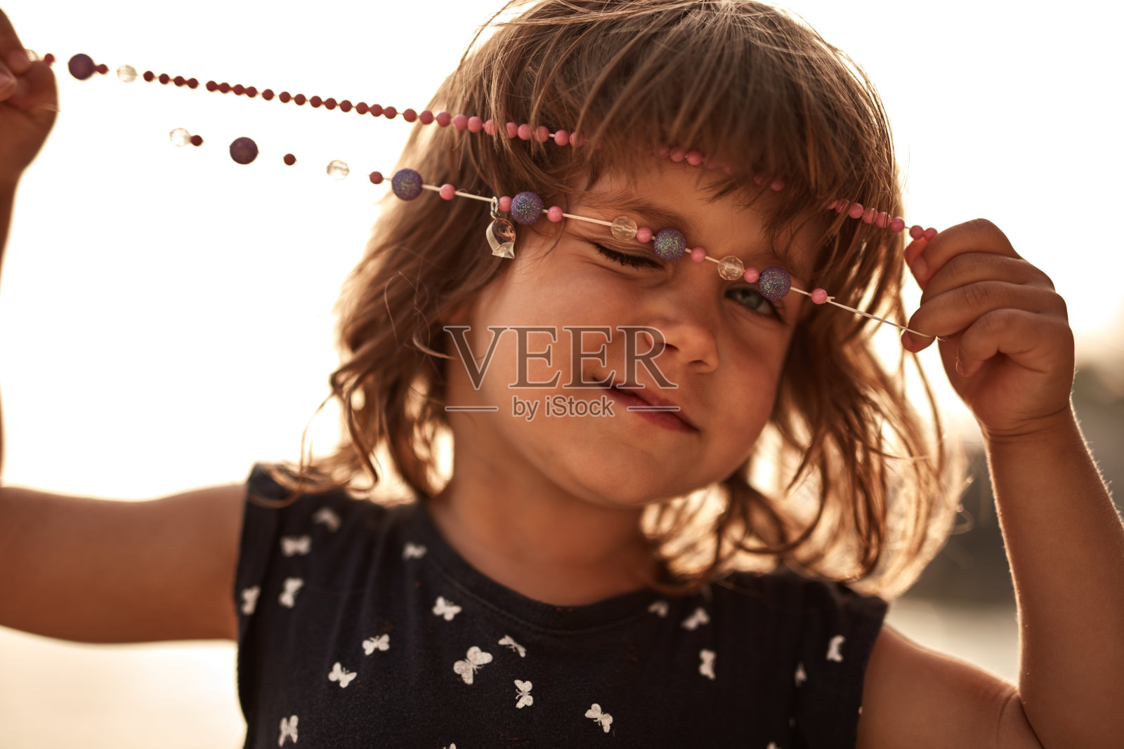 可爱的小女孩在镜头前摆姿势。照片摄影图片