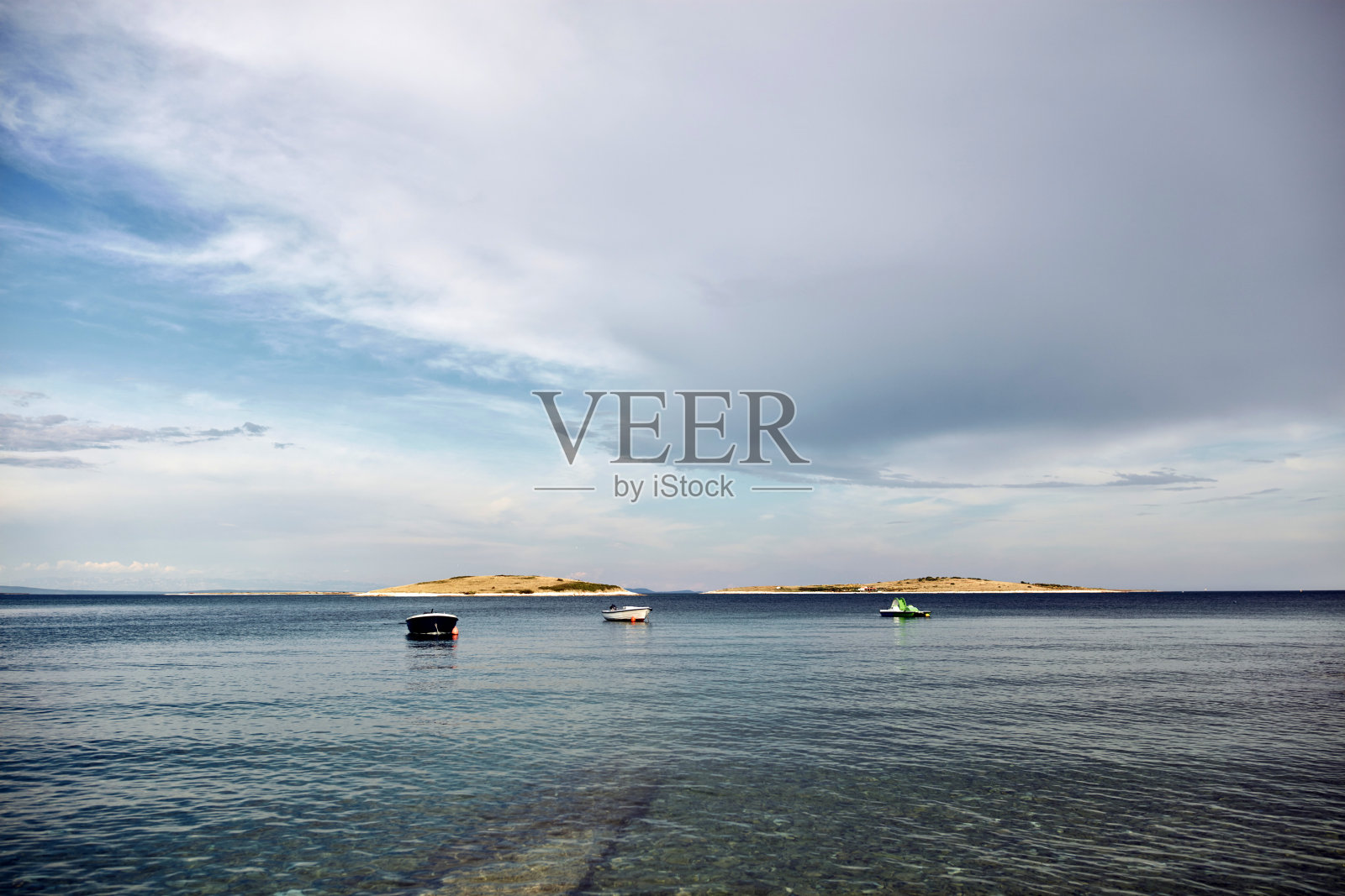 海面上有小船，海面平静。照片摄影图片