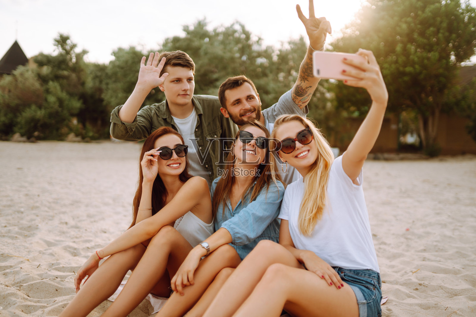 有问题的时间。一群朋友在用手机自拍。照片摄影图片