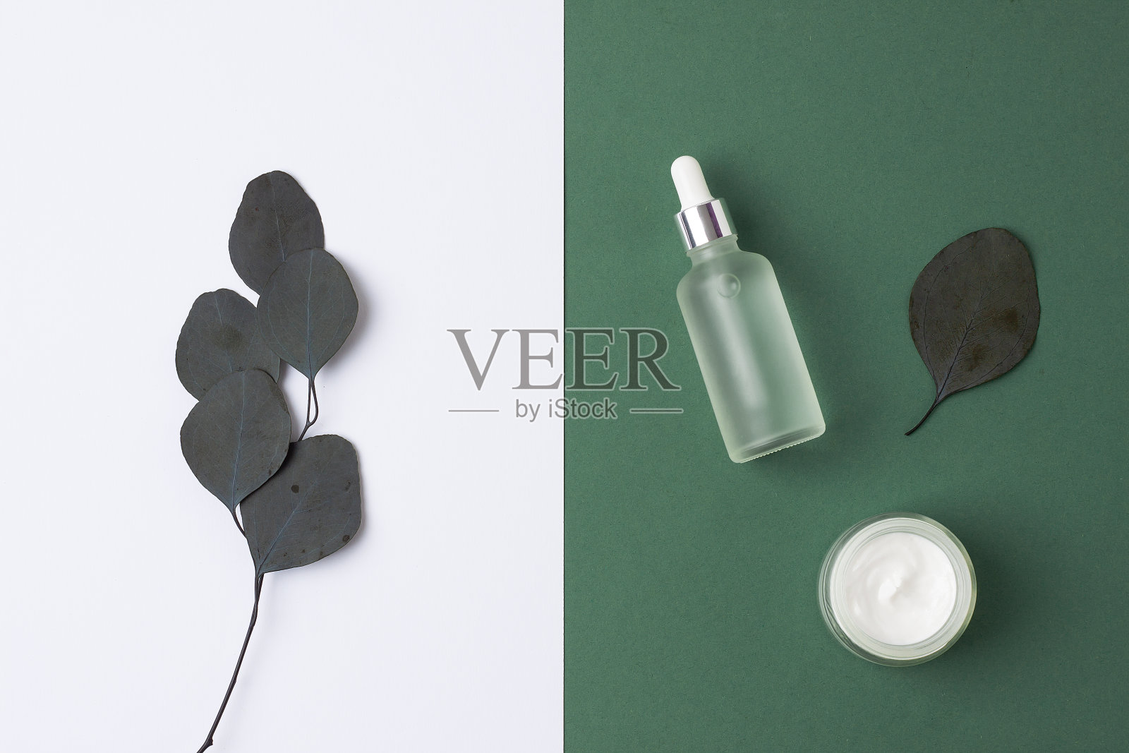 最小的组成与化妆品护肤产品和桉树在绿色的背景。平的。照片摄影图片