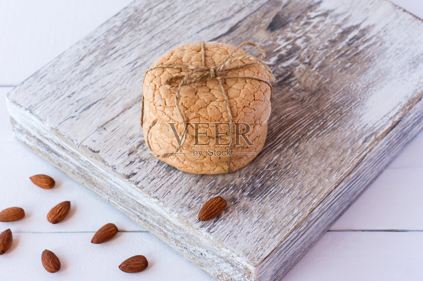 用杏仁粉做成的四合节甜饼堆放在白色的木砧板上，以白色的木为背景。有选择性的重点照片摄影图片