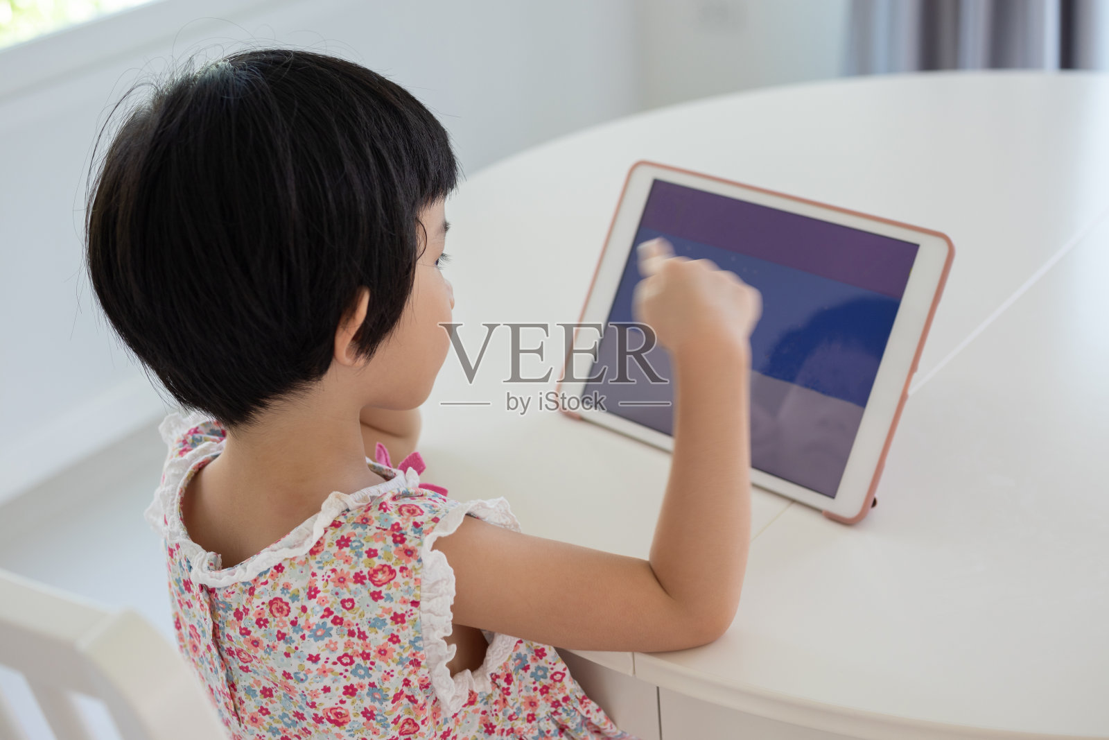 一个亚洲小女孩在家玩平板电脑照片摄影图片