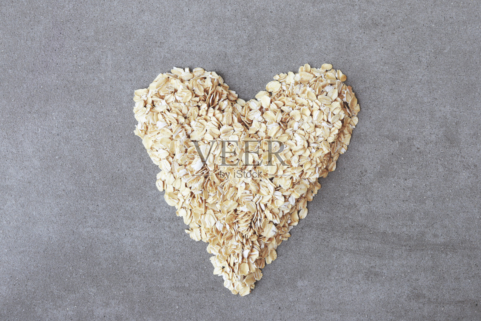 大理石背景上的心形燕麦生颗粒照片摄影图片