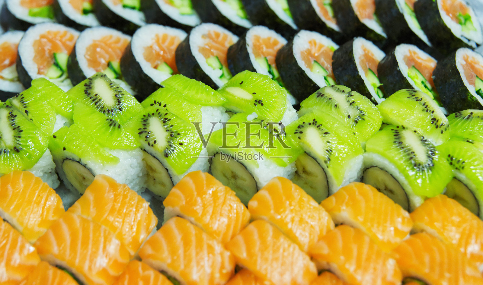 特写的美丽的日本寿司与猕猴桃和鲑鱼照片摄影图片