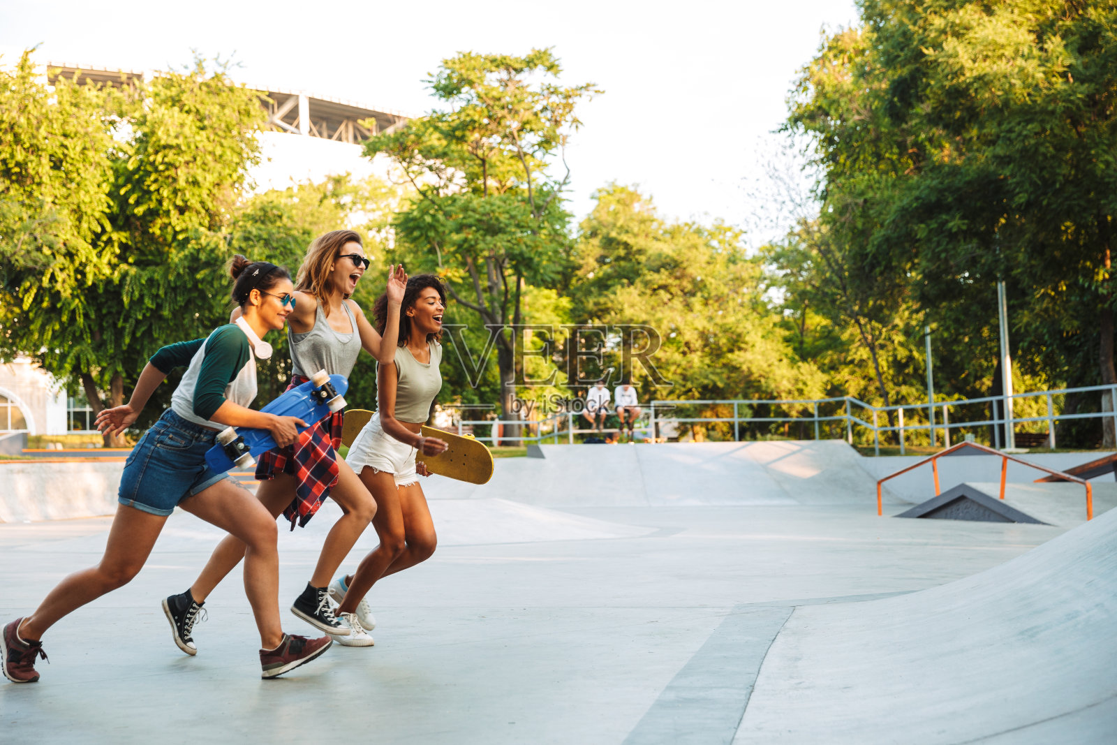 三个欢快的年轻女孩玩着滑板照片摄影图片