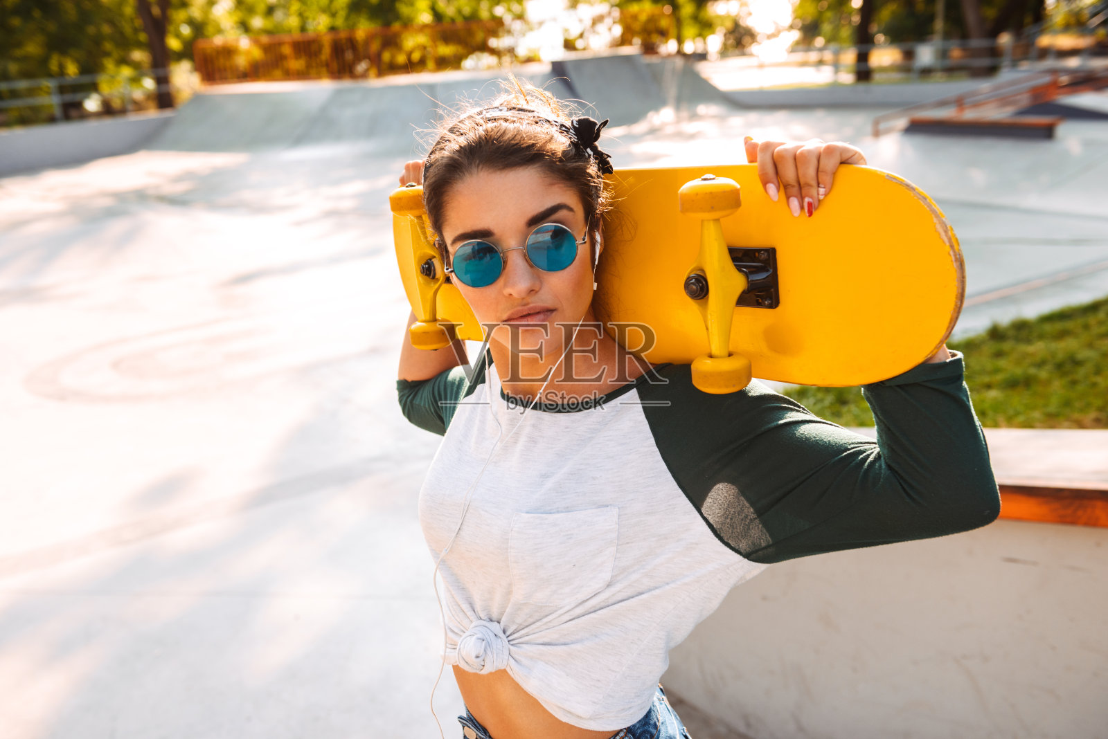 带着滑板在户外散步的漂亮女人照片摄影图片
