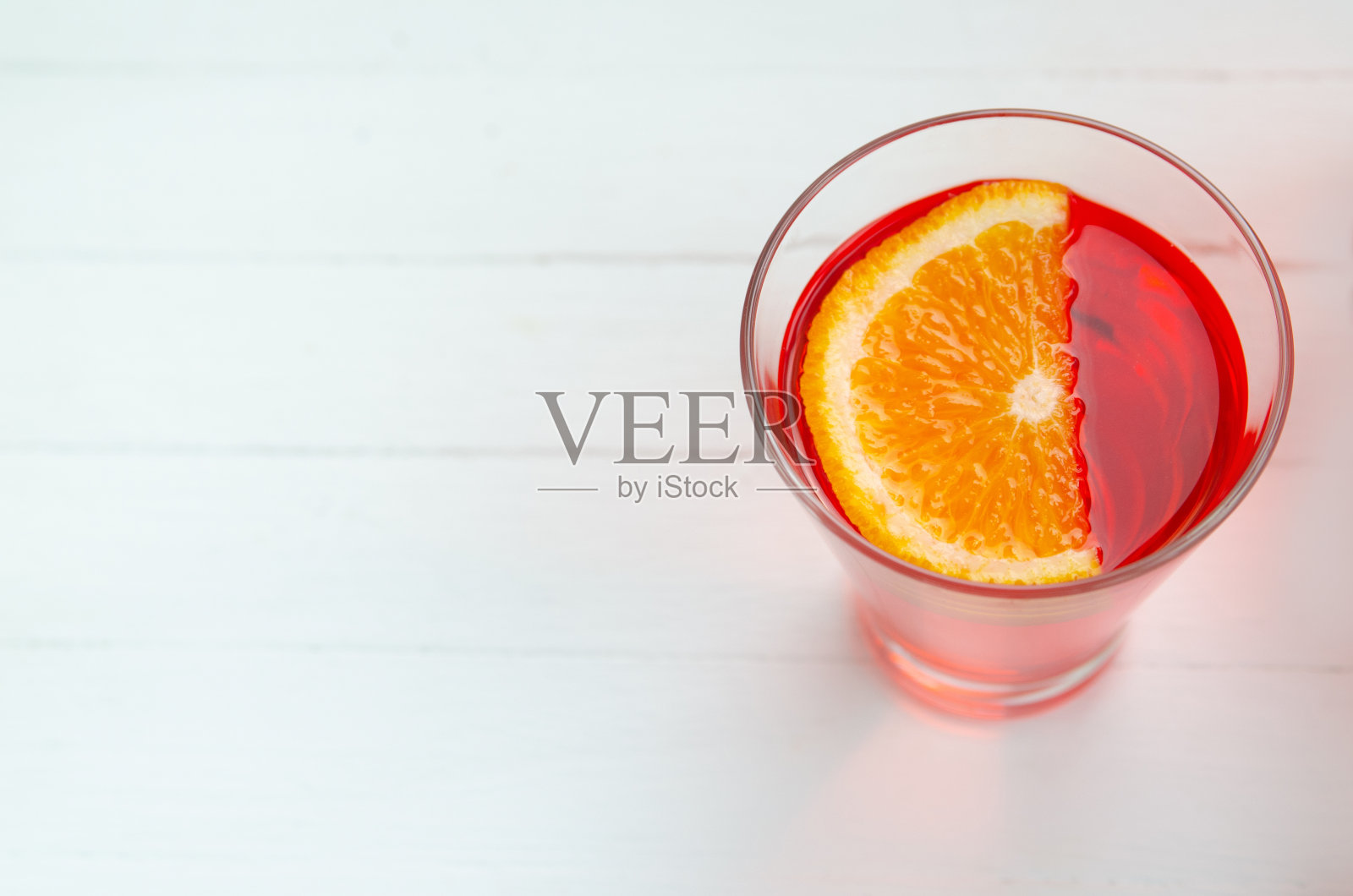 红色樱桃饮料在一个透明的容器在白色的背景照片摄影图片