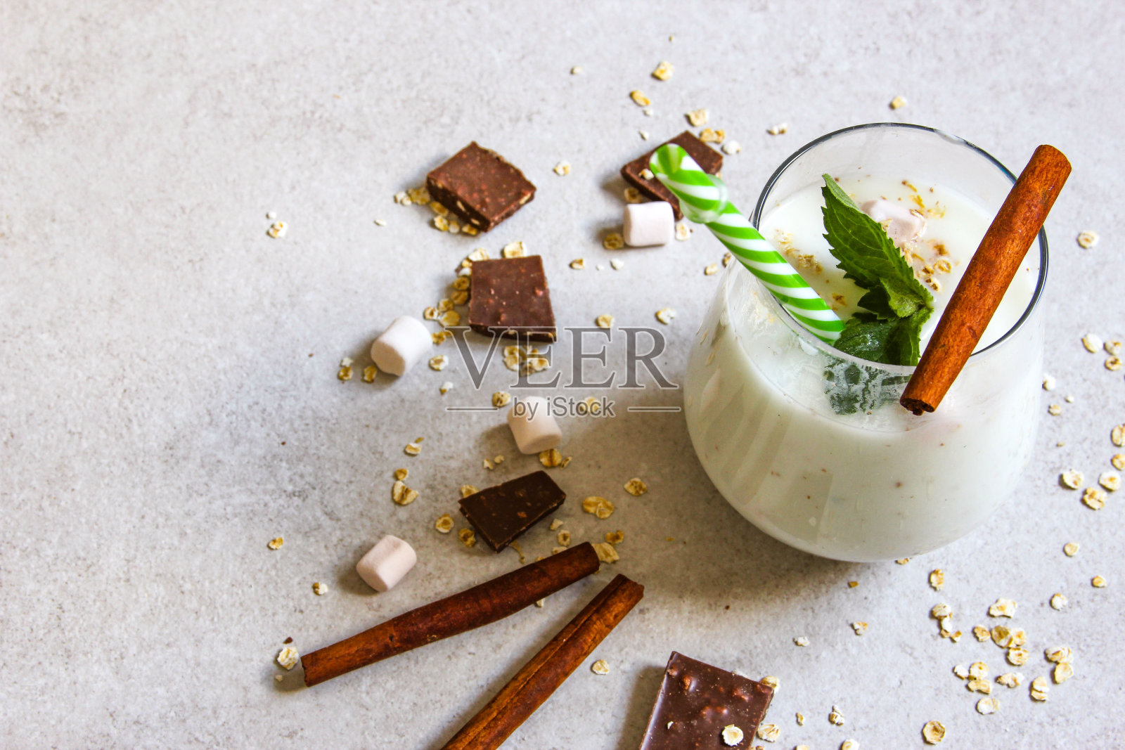 在灰色的背景上有天然酸奶、巧克力和麦片的冰沙碗。健康的早餐。照片摄影图片