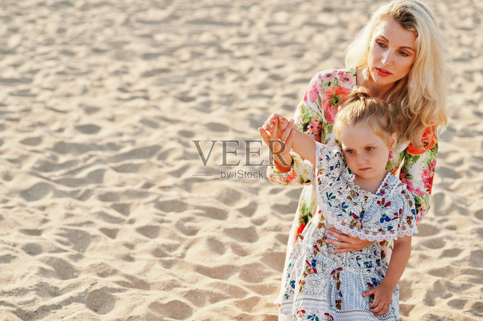 妈妈和漂亮的女儿在海滩上玩得很开心照片摄影图片