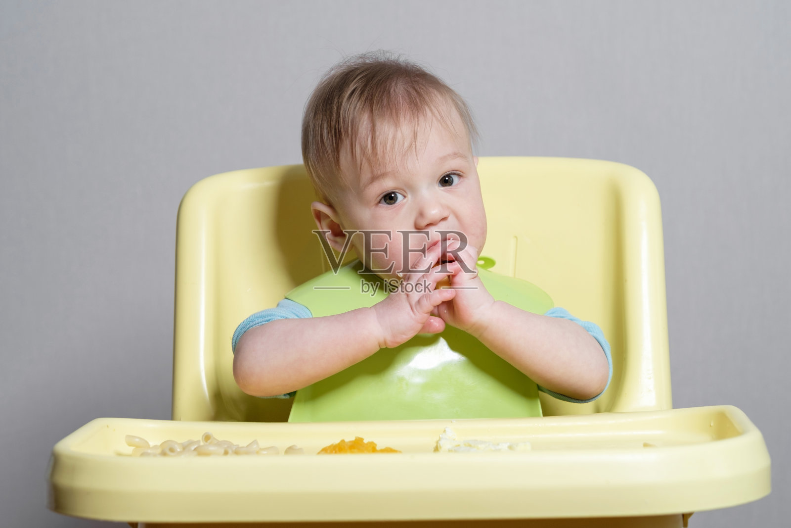 小孩子在灰色背景上吃东西照片摄影图片