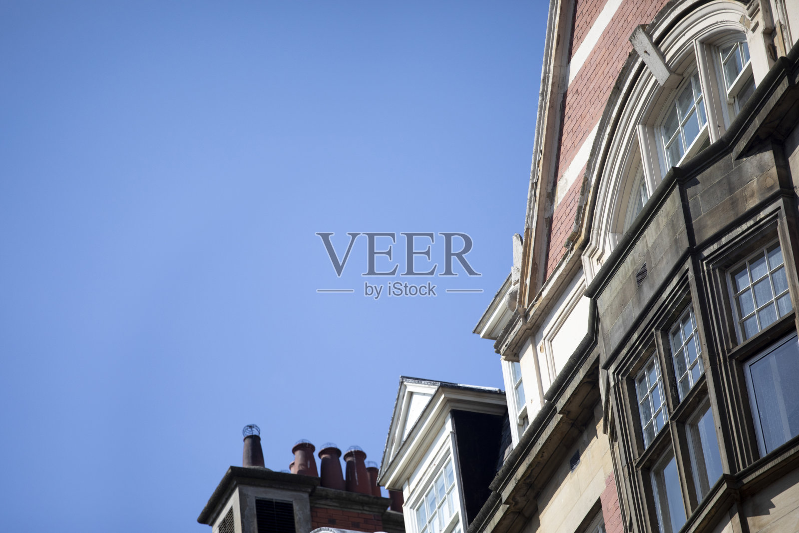 从低角度看，城市建筑映衬着清澈的蓝天照片摄影图片