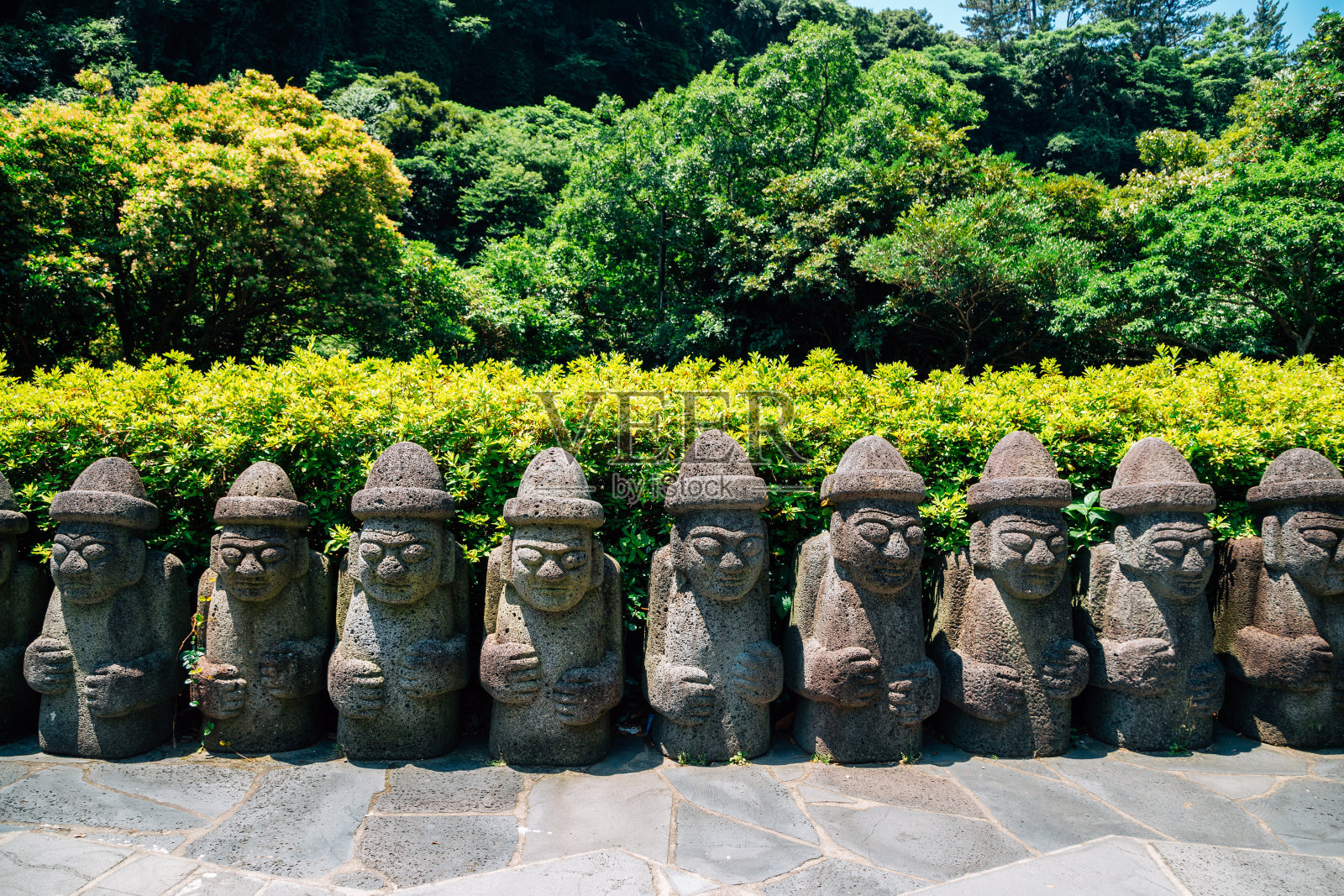 韩国济州岛天池渊瀑布的石爷爷雕塑照片摄影图片