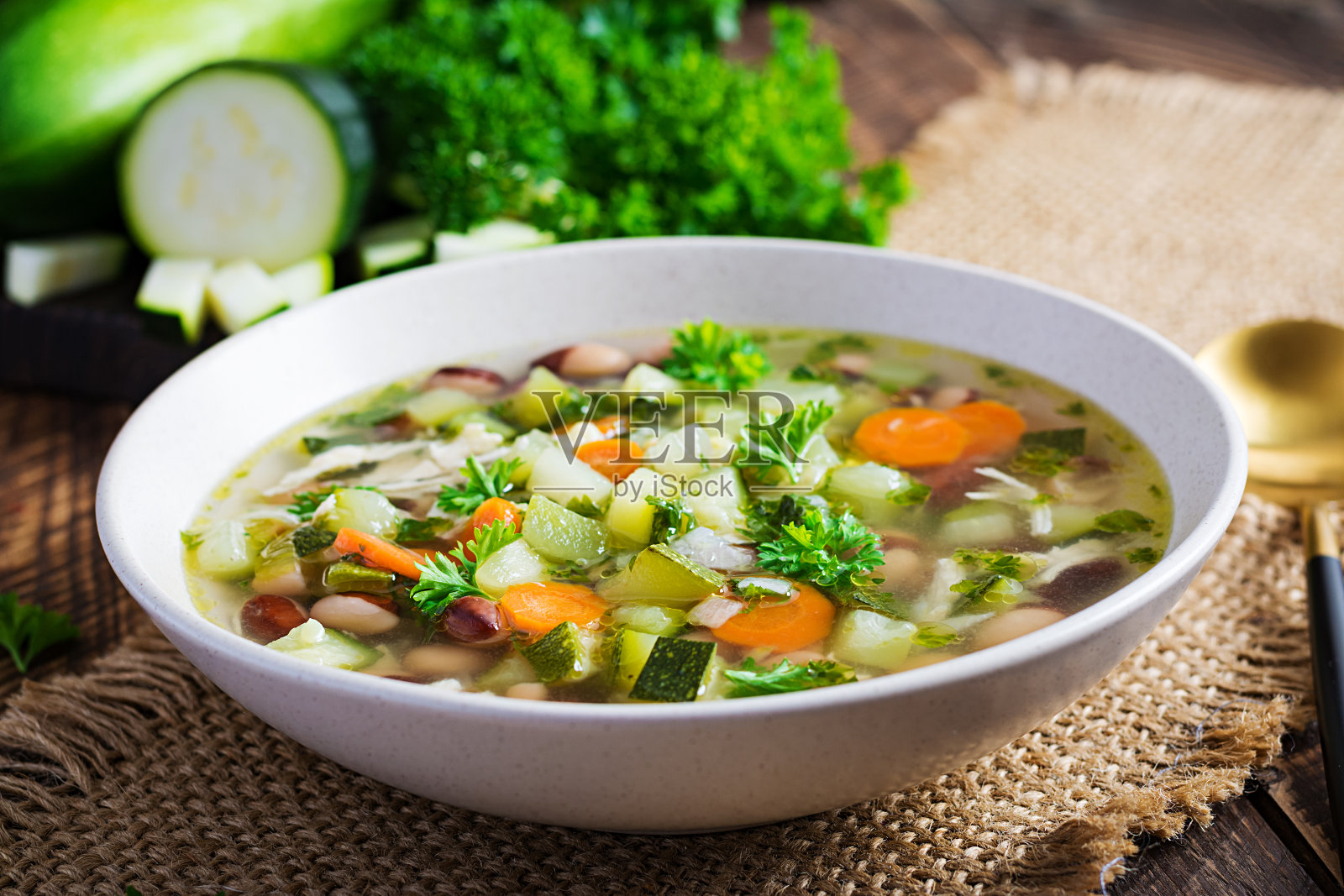 鸡柳蔬菜汤碗在木制的乡村桌子。照片摄影图片