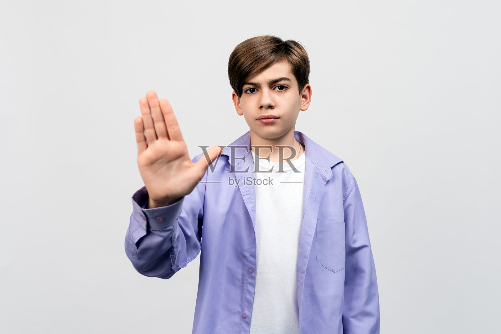 不。严肃的男孩显示停止禁止手势，保持距离，远离后退标志照片摄影图片