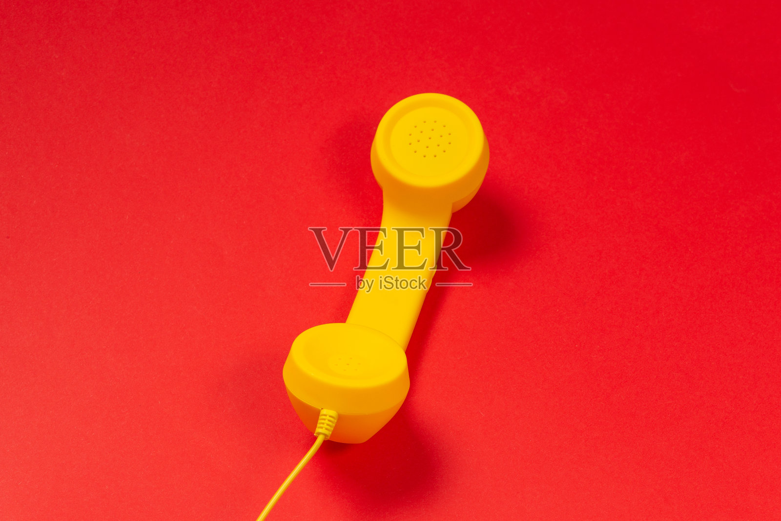 红色背景上的黄色手机。副本的空间。照片摄影图片