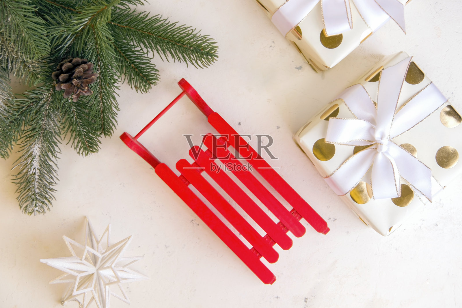 新年假期概念。白色背景上的红色雪橇旁边是礼物。从上面的观点照片摄影图片