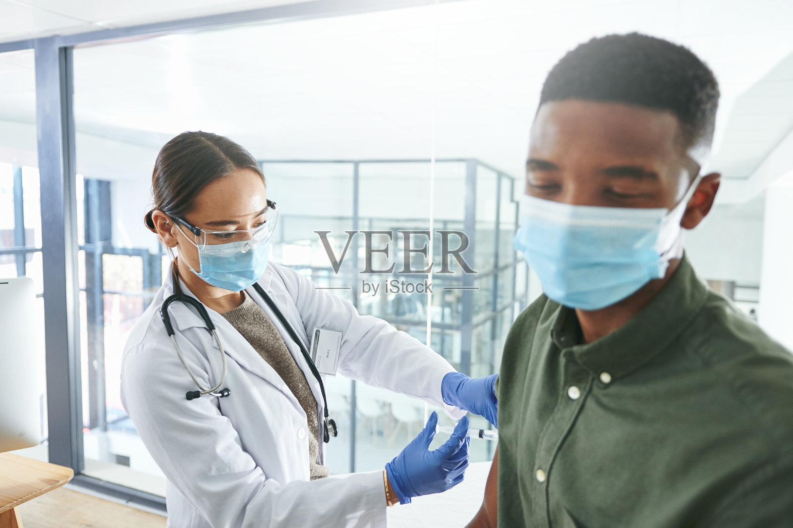 一名年轻医生在办公室给病人打针照片摄影图片