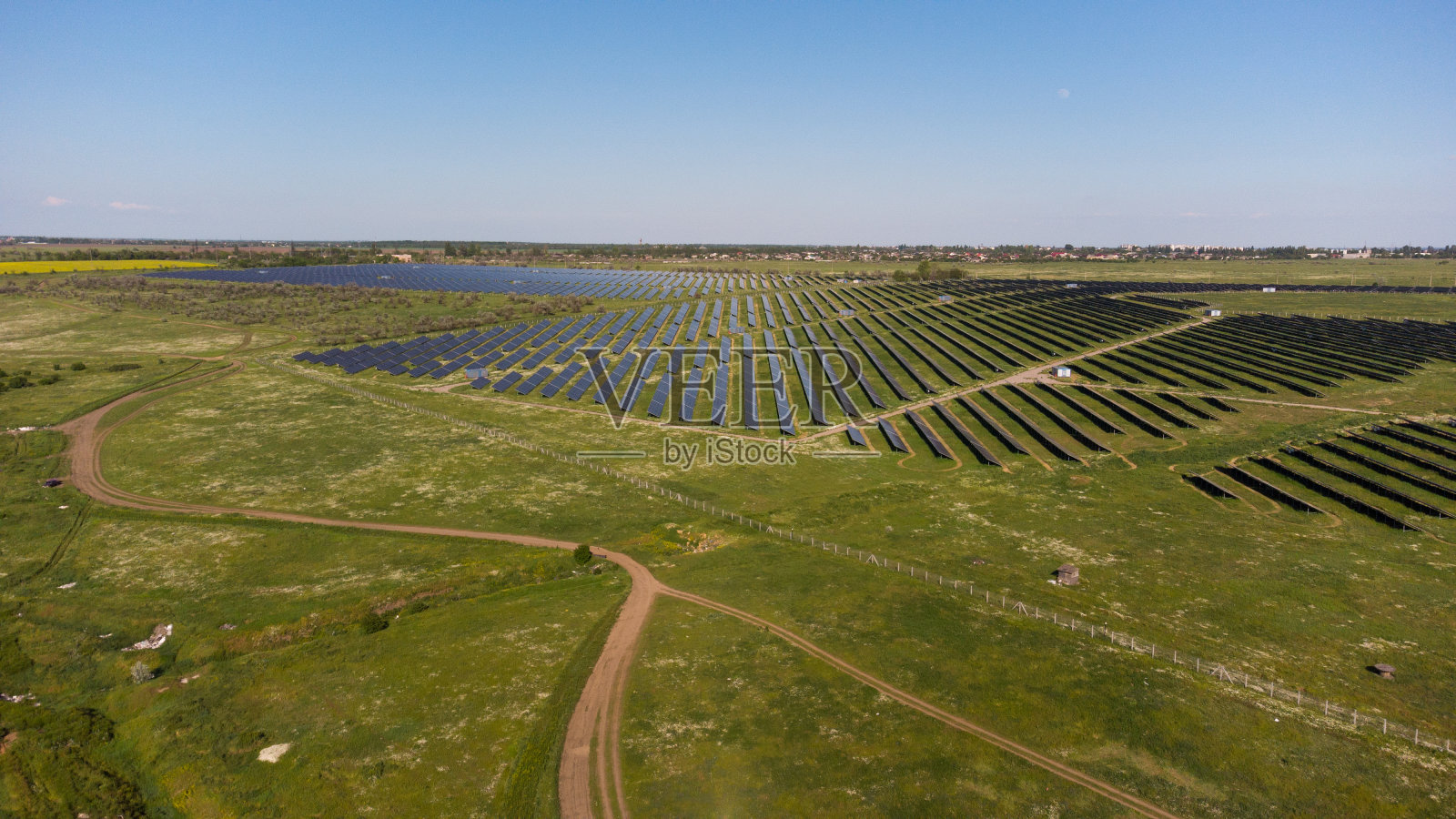绿色田野中的太阳能电池板鸟瞰图。替代形式的生态能源照片摄影图片