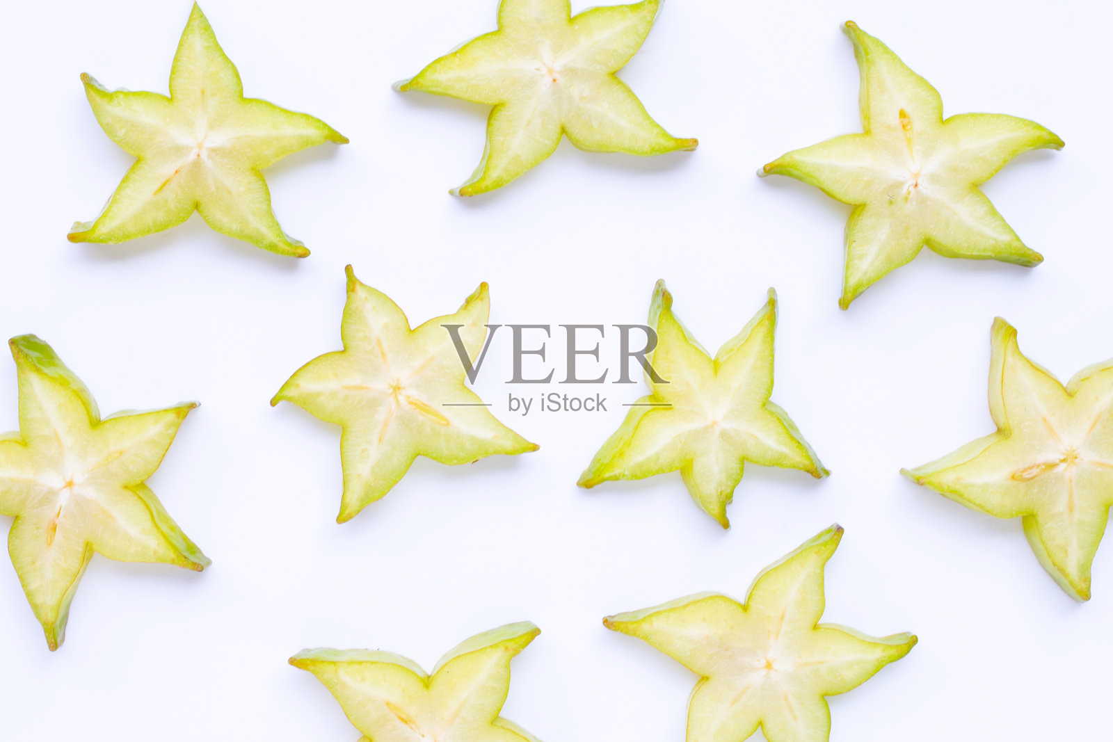 白色背景上的绿色杨桃片。照片摄影图片