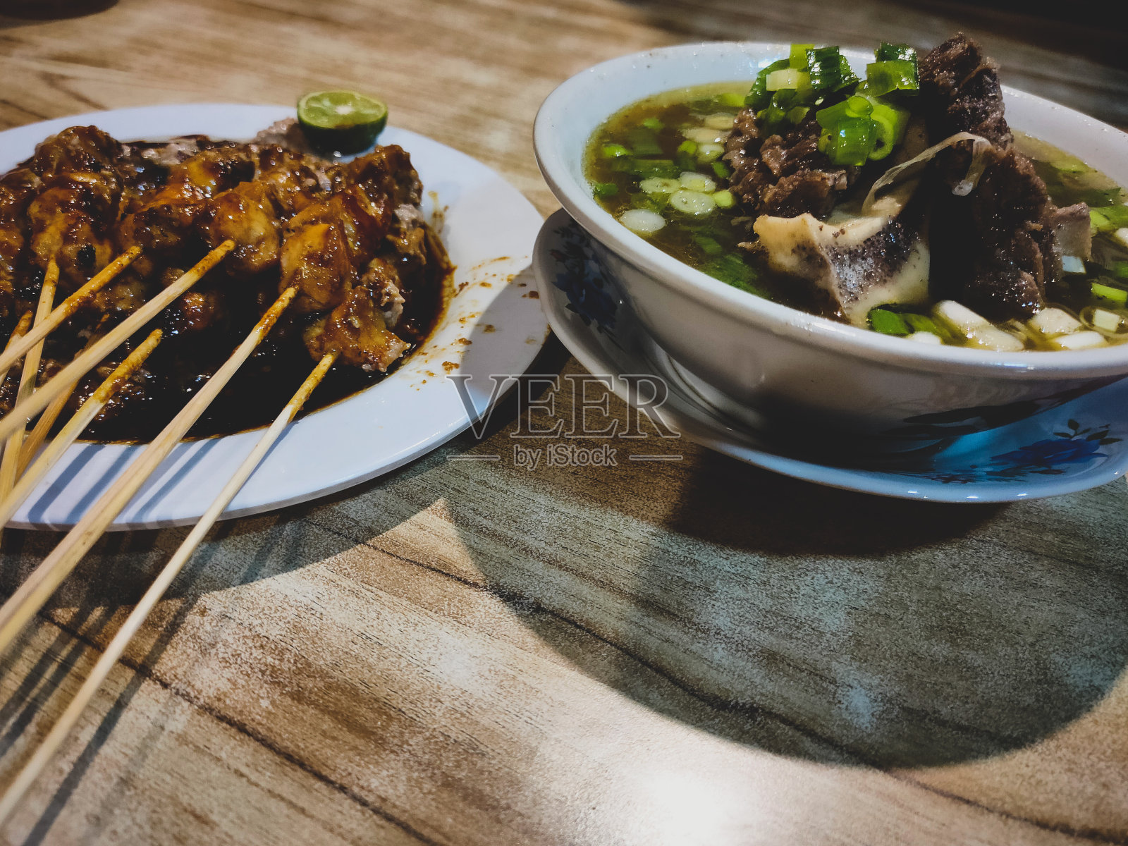 木桌上放着肉汤和沙茶照片摄影图片