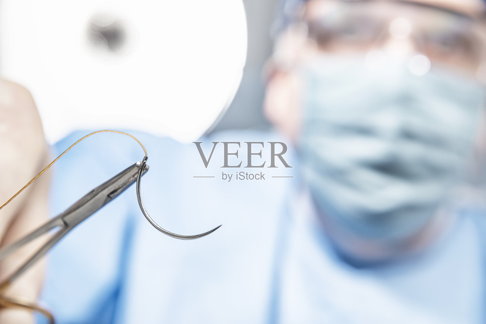 外科医生手持的外科缝合针和线的特写照片摄影图片