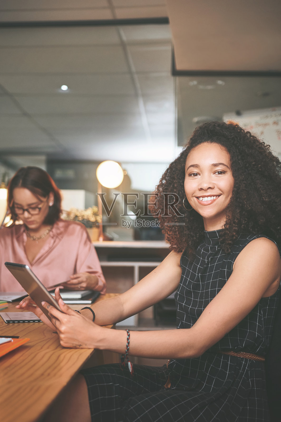 这是一位迷人的年轻女商人坐在办公室开会时使用数码平板电脑的照片照片摄影图片