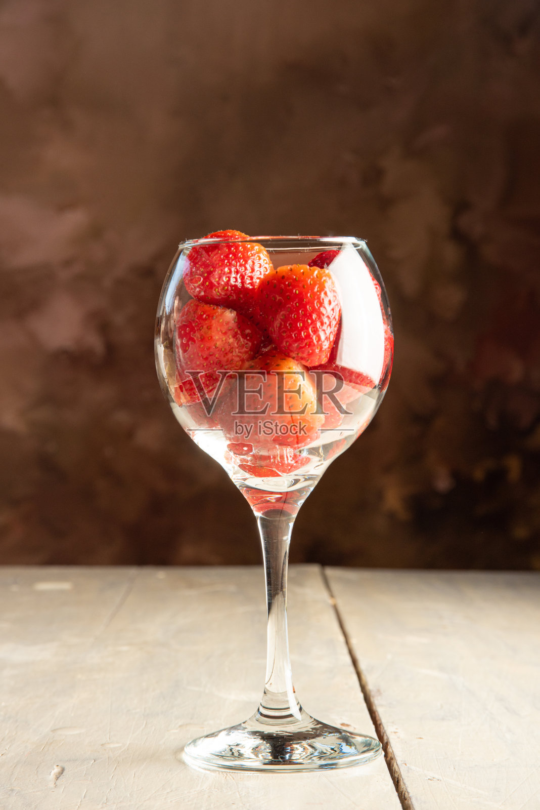 草莓，一碗草莓放在旧的白色桌子上，黑色抽象背景，选择性聚焦。照片摄影图片