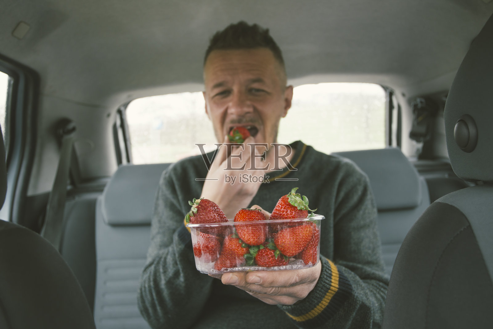 从水果塑料容器里吃草莓照片摄影图片