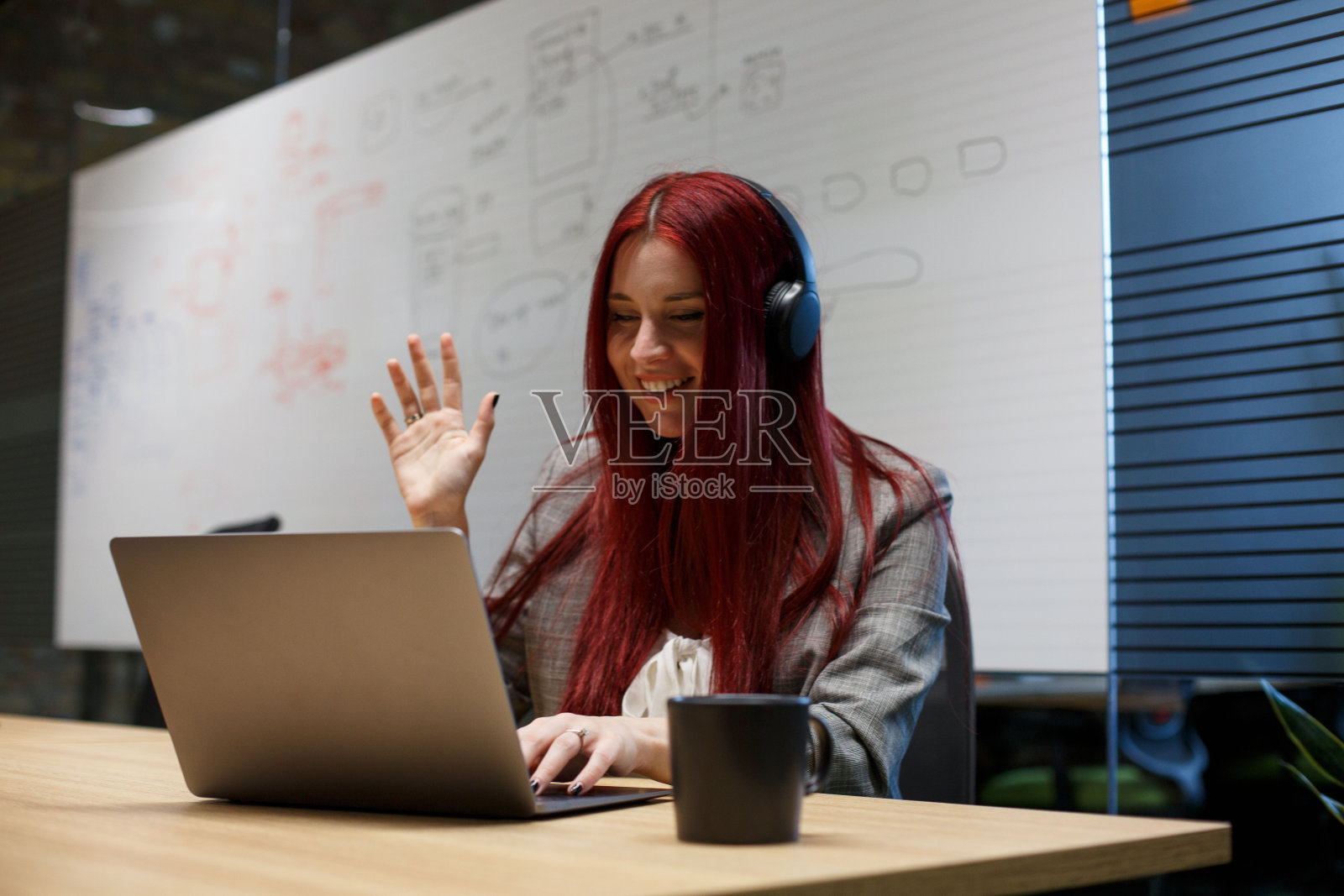年轻女子在镜头的另一边向同事挥手。照片摄影图片