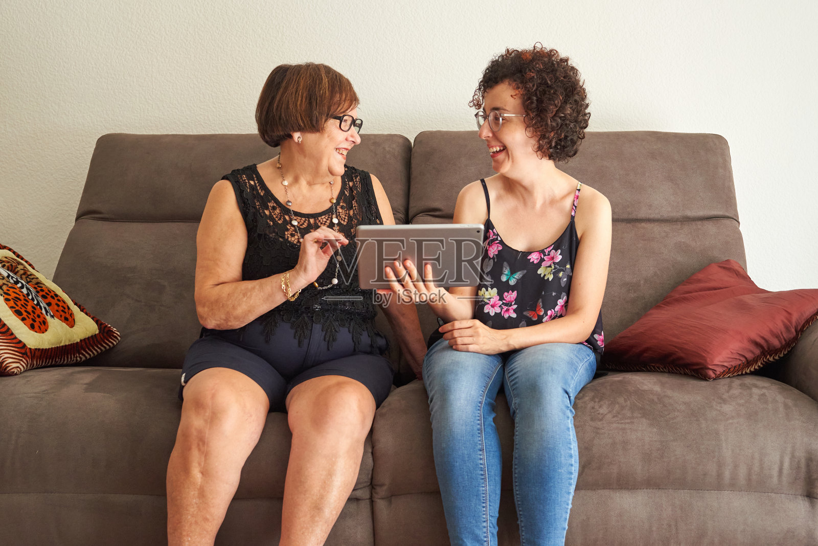 祖母和孙女在平板电脑上看数字内容时大笑照片摄影图片