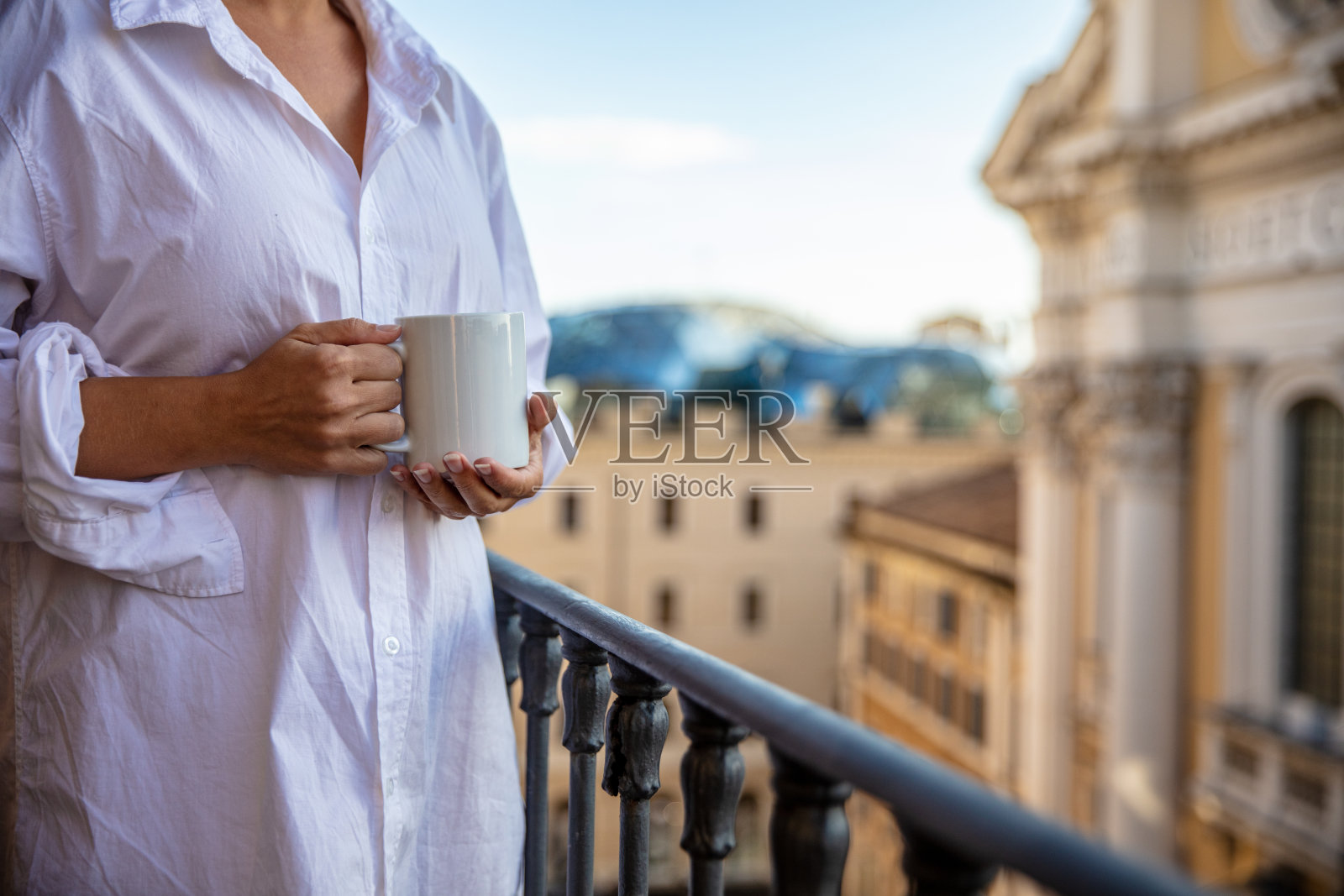 阳台上拿着咖啡杯的女人照片摄影图片