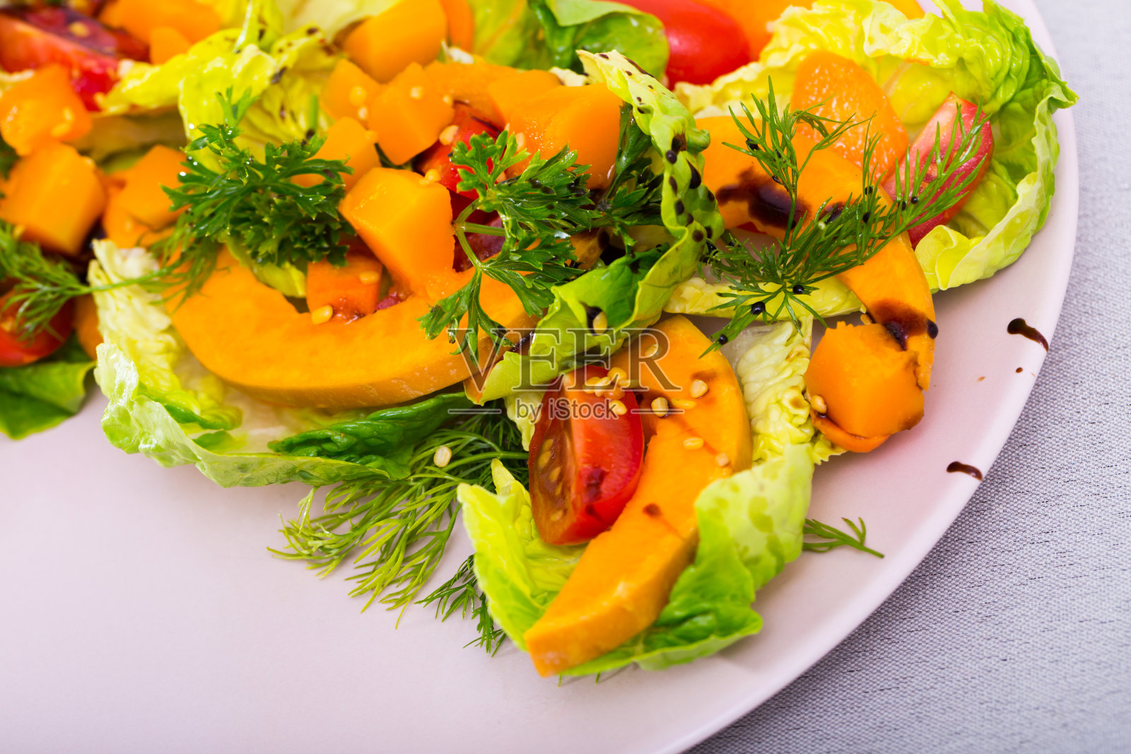 美味的烤南瓜，樱桃番茄，芝麻和酱汁沙拉照片摄影图片