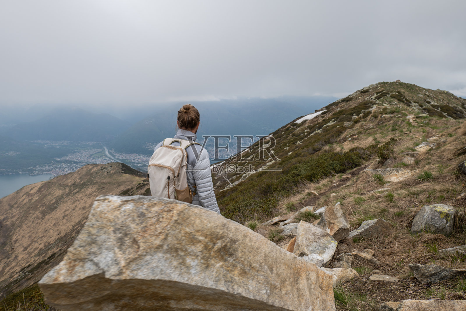 年轻男人在山脊上徒步旅行，阴天照片摄影图片
