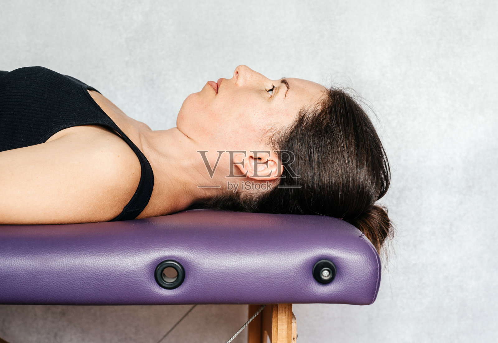 一位女士在健康中心的按摩床上休息照片摄影图片