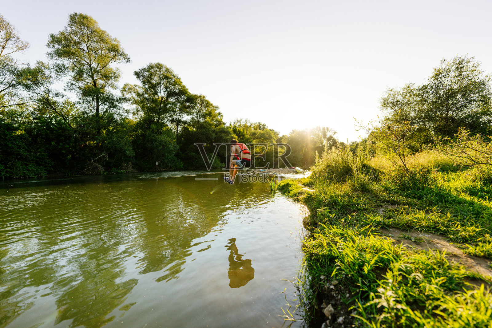 小男孩跳进河里照片摄影图片
