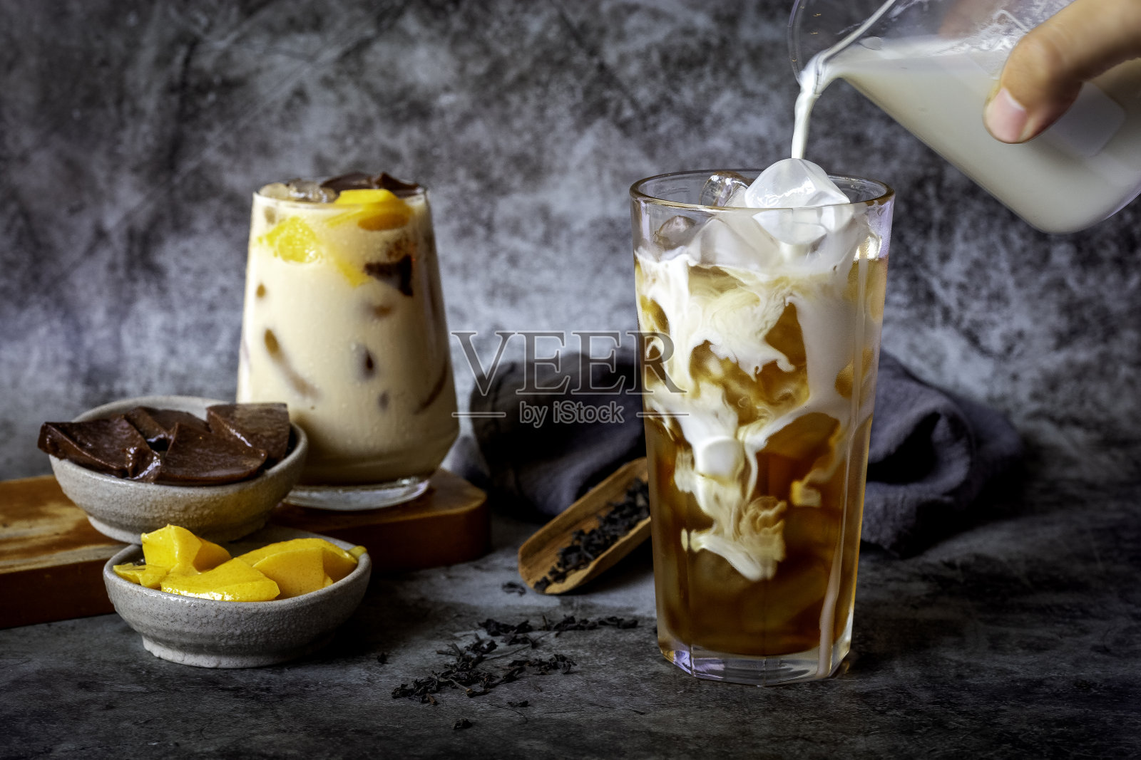 把牛奶倒进一杯奶茶里照片摄影图片