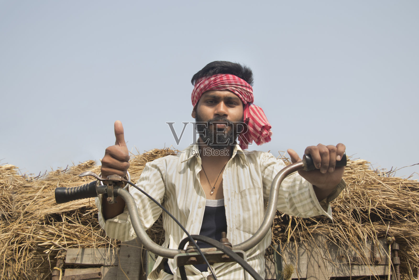 年轻的成年人开着机器人力车，竖起大拇指照片摄影图片