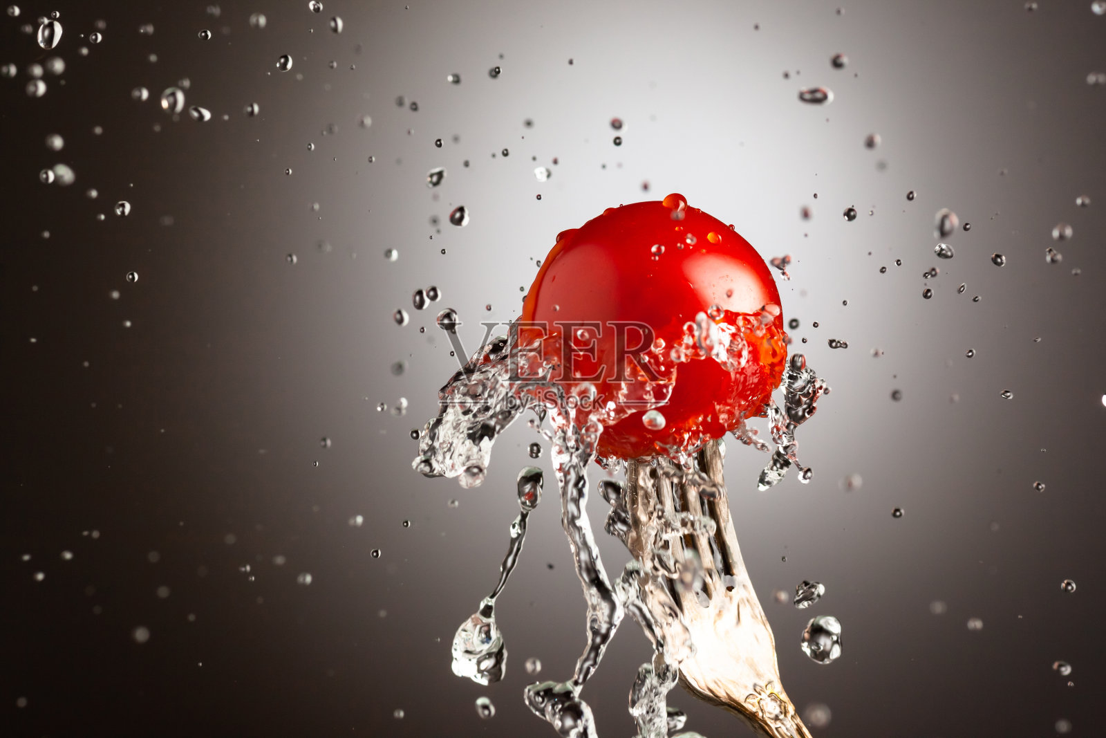 用叉子把水洒在成熟的樱桃番茄上。黑白渐变背景下，放置文字照片摄影图片