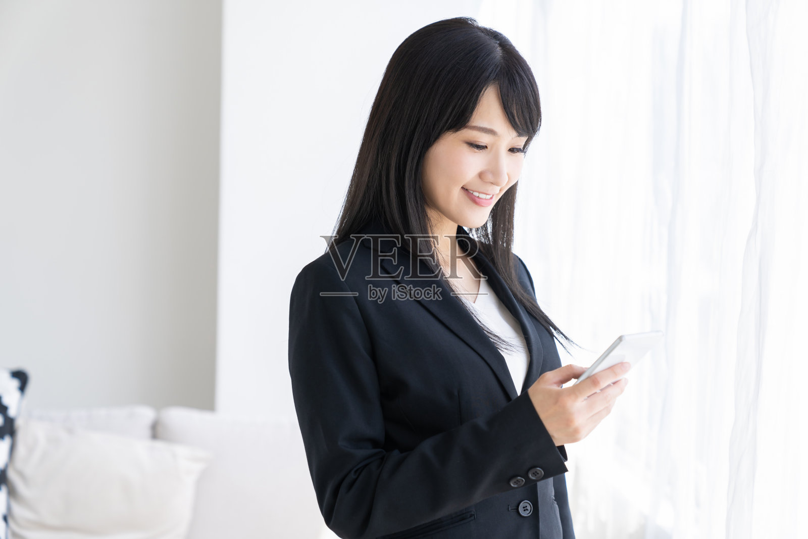 年轻迷人的亚洲女商人，智能手机照片摄影图片